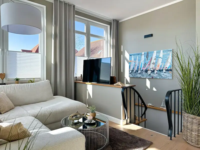Ferienwohnung Inselrose Juist – Essbereich mit Holztisch, Stühlen und großem Fenster